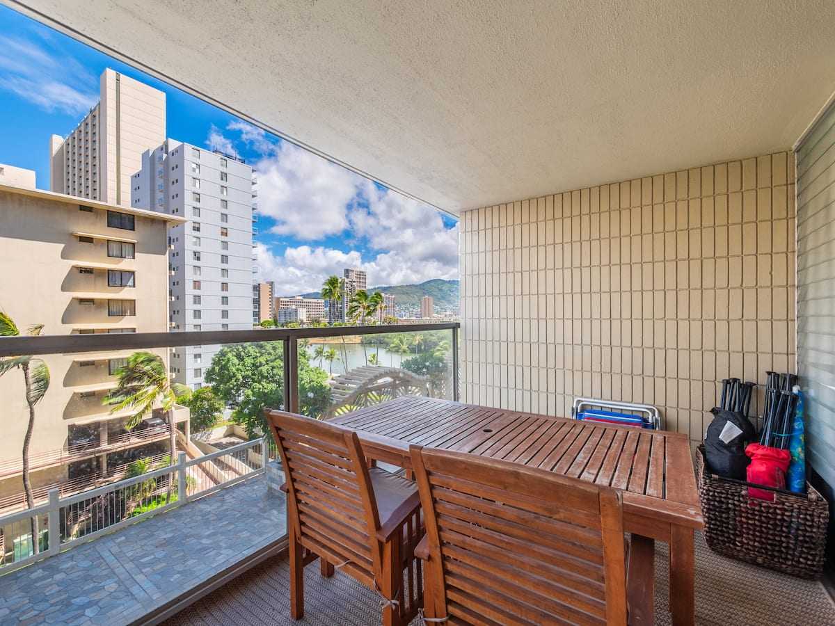 Lanai dining table with city buildings beyond the railing