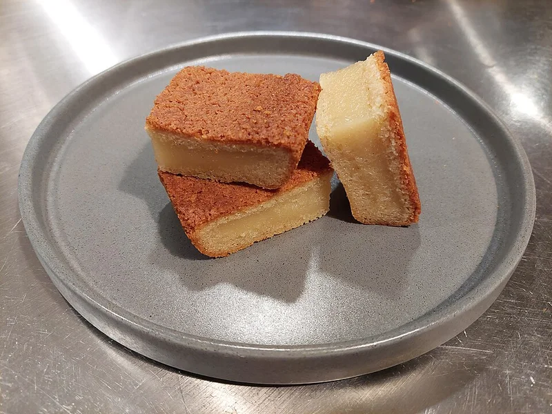 Slices of butter mochi showing their browned crust and dense center.