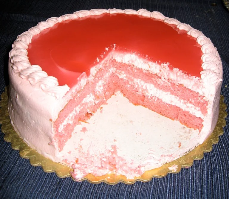 Guava chiffon cake with a slice removed to show its pink layers.