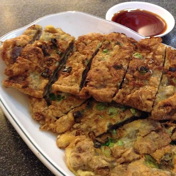 Sliced meat jun on a plate with dipping sauce.