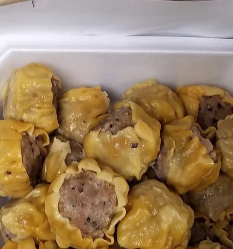 Pork hash dumplings with yellow wrappers.